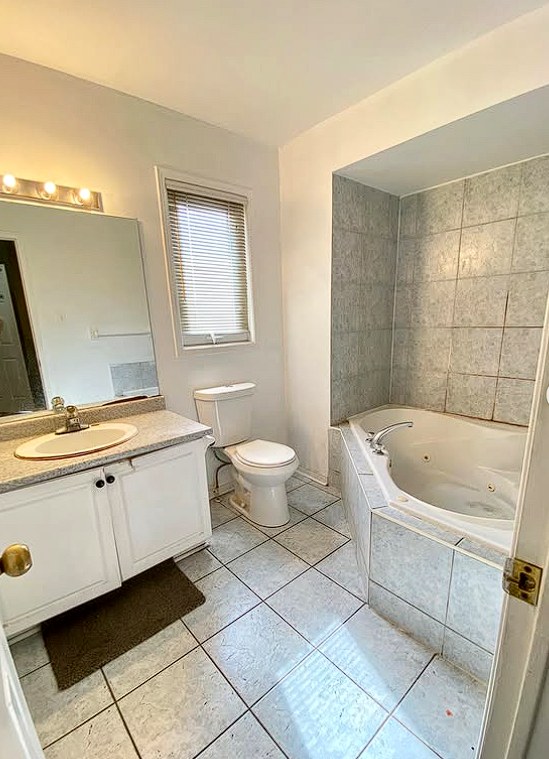 Dated bathroom with a corner soaker tub before renovation